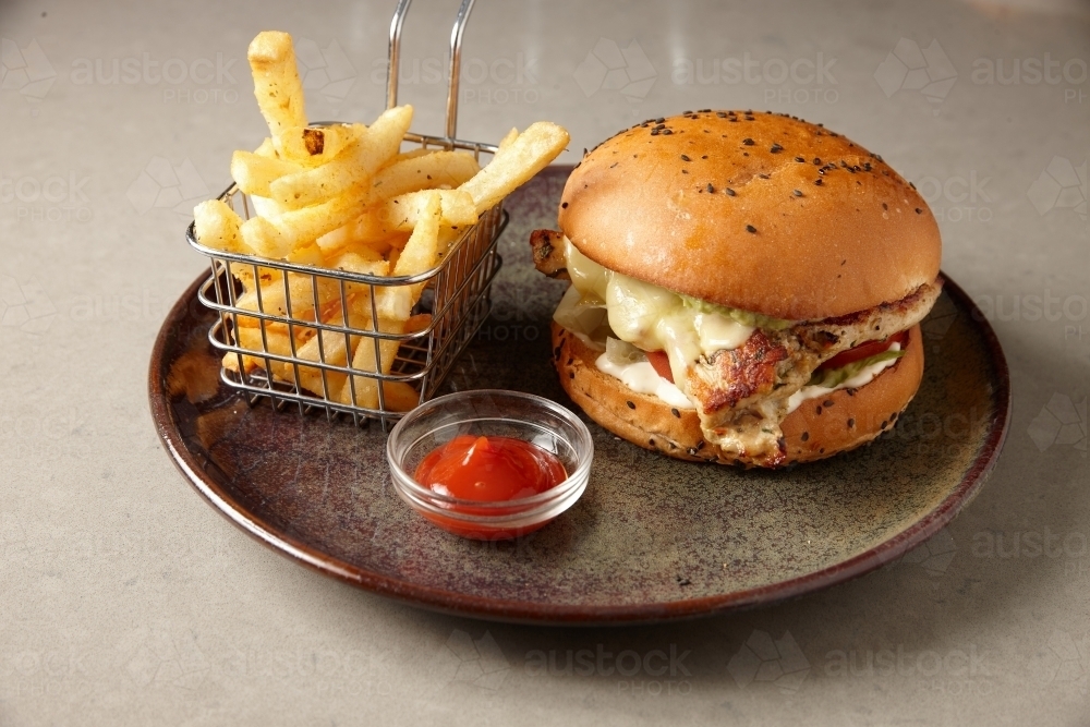 Close up of tasty hamburger and fries on plate - Australian Stock Image