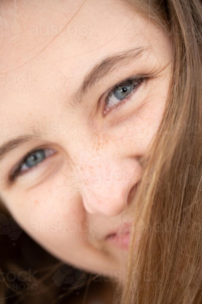 Close-up of teenage girl's face obscured by hair - Australian Stock Image