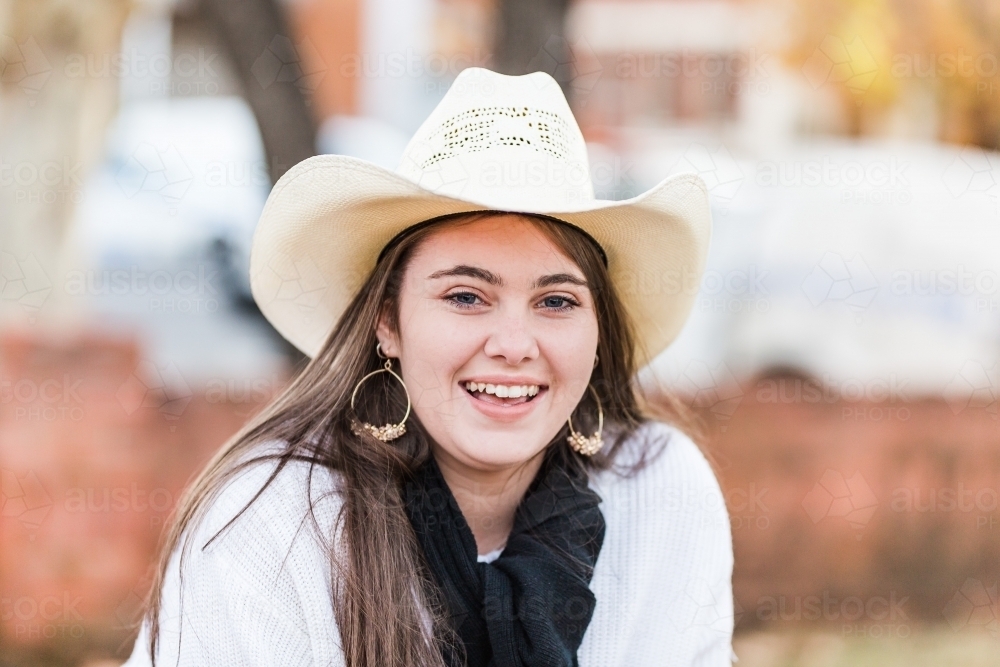 Close up of teenager smiling in hat and scarf - Australian Stock Image