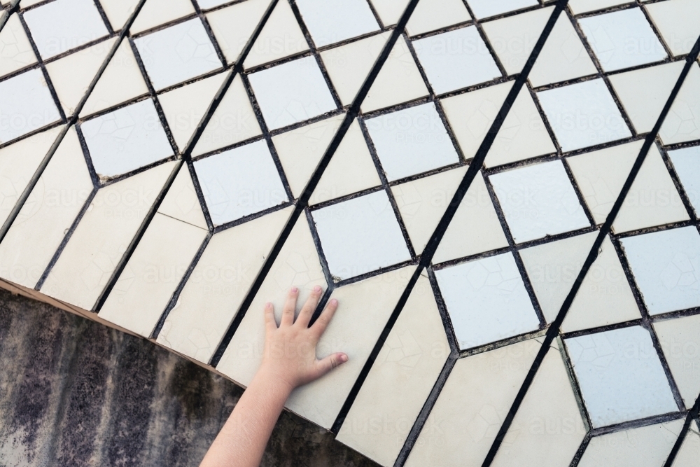 close up of tiles on Sydney Opera House with kids hand - Australian Stock Image