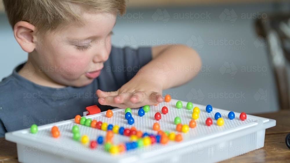 Close up of toddler playing puzzle game - Australian Stock Image