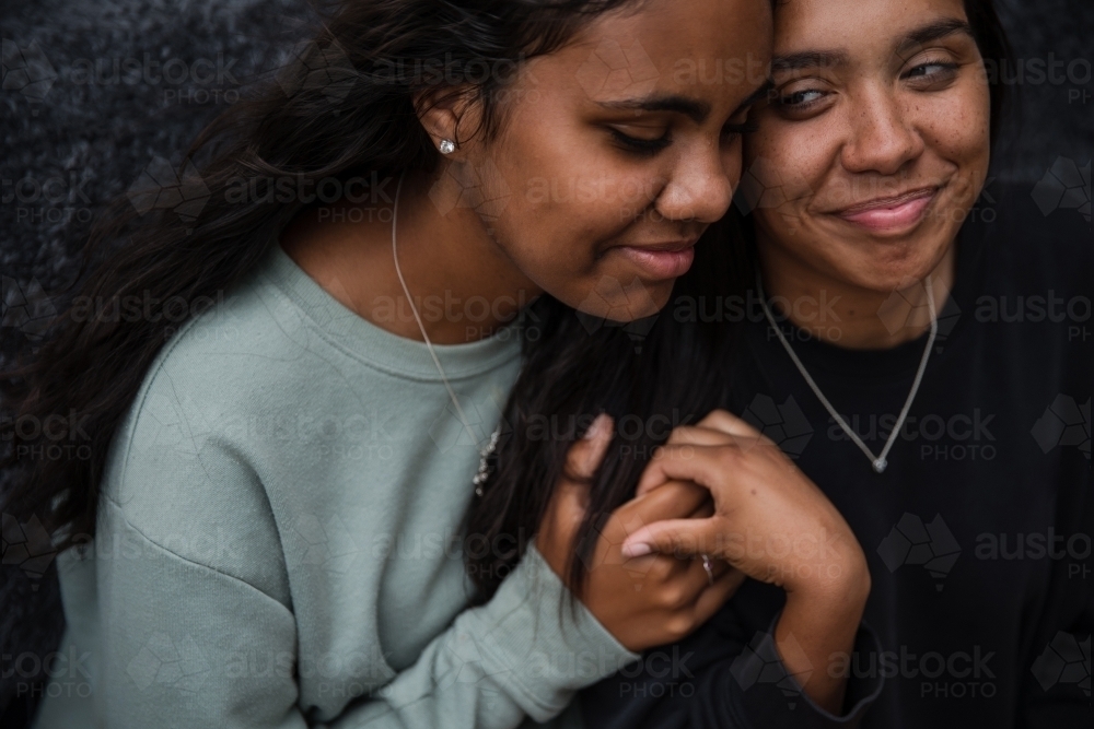 Close-up of two Aboriginal girls hugging - Australian Stock Image