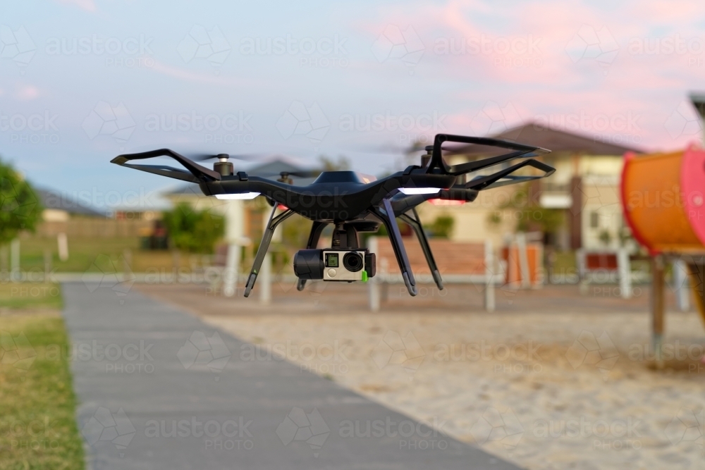 Close-up of UAV, RPAs, drone with camera attached landing in an empty park - Australian Stock Image