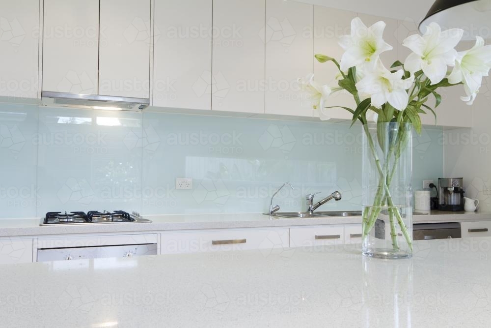 Close up of white flowers in contemporary what kitchen - Australian Stock Image