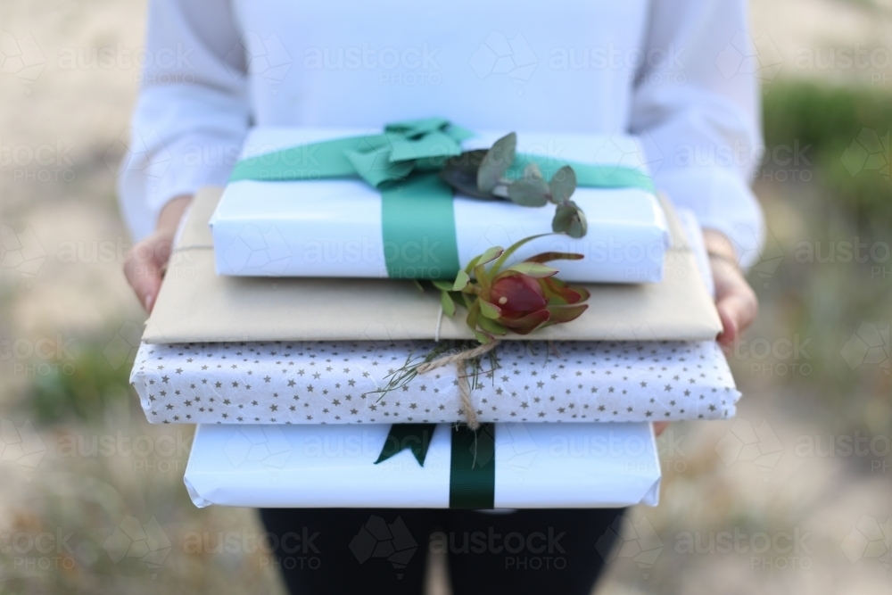 Close up of woman holding presents at beach - Australian Stock Image