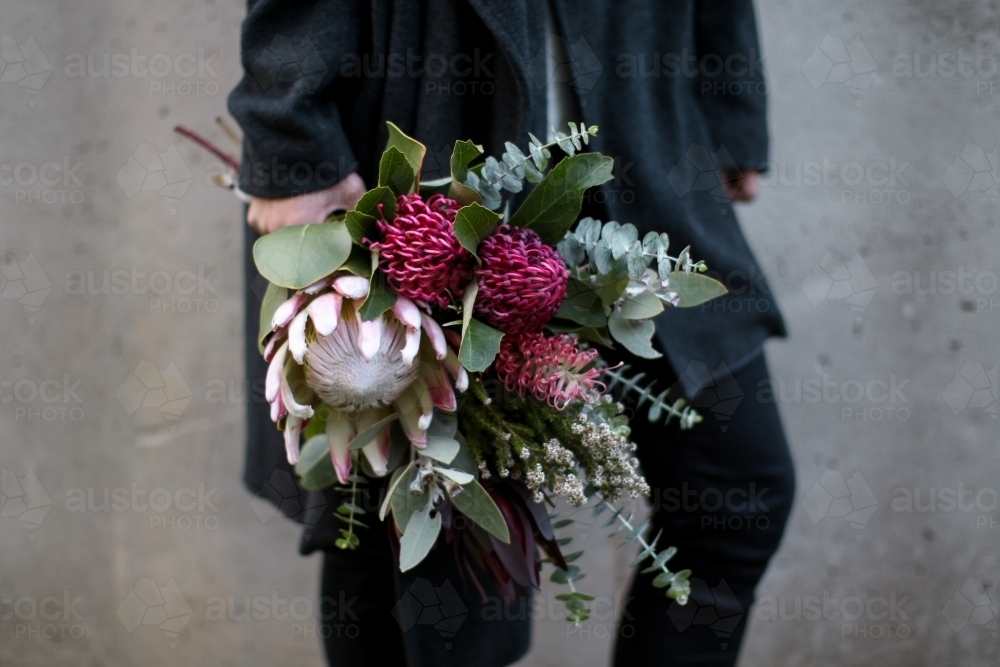 Close up of woman's hand holding a bouquet of native flowers - Australian Stock Image