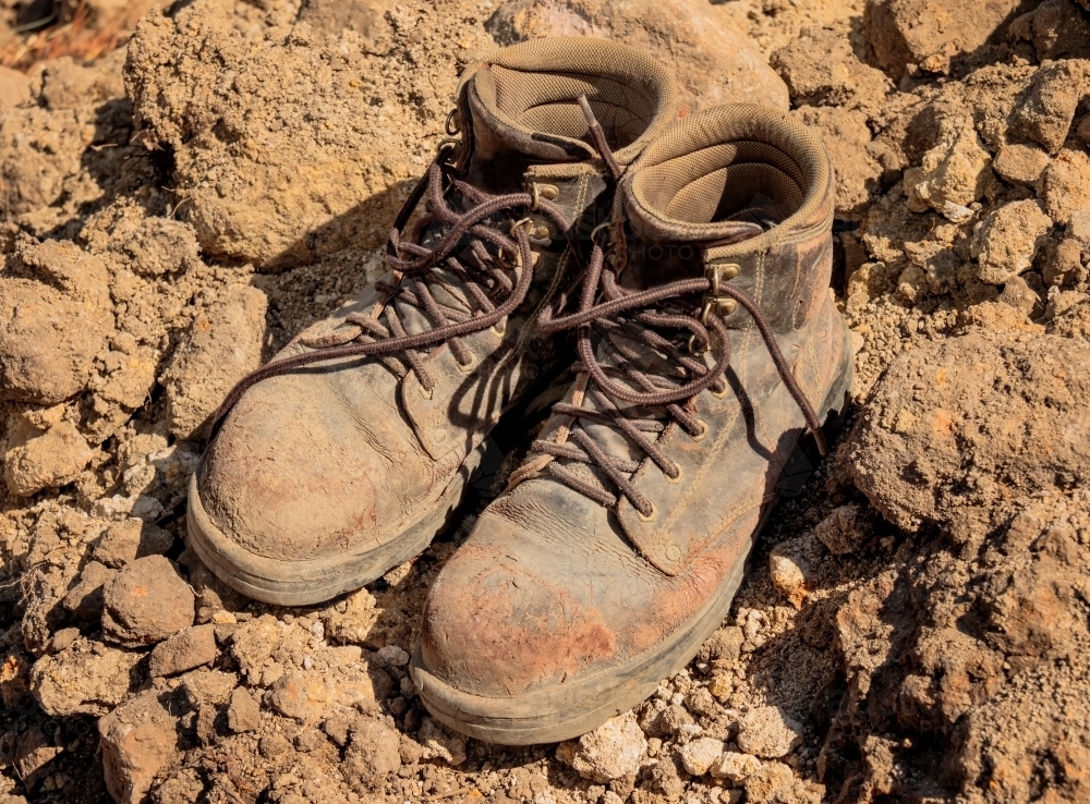 Close-up of worn leather tradesman's work boots on building site - Australian Stock Image