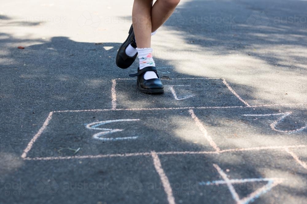 Close up of young girls legs on a hopscotch game - Australian Stock Image