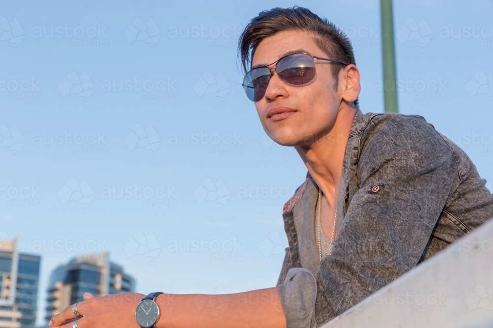 Close up of young latino male watching sunset - Australian Stock Image