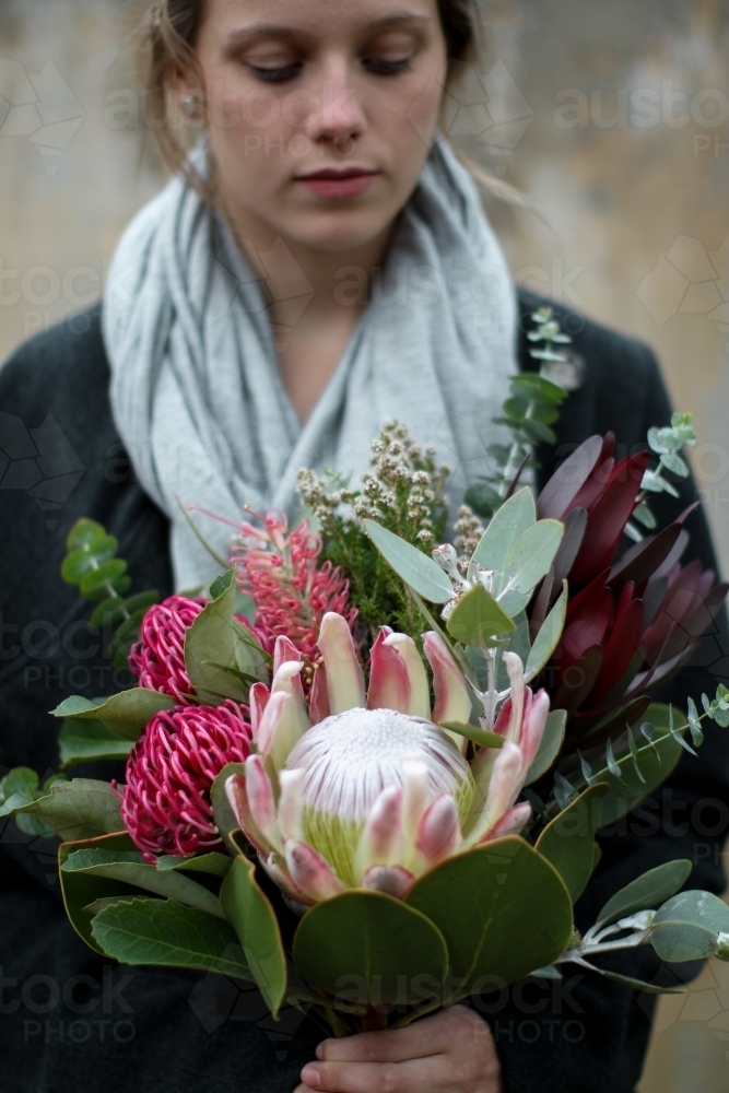 Close up of young woman holding a bouquet of native flowers - Australian Stock Image