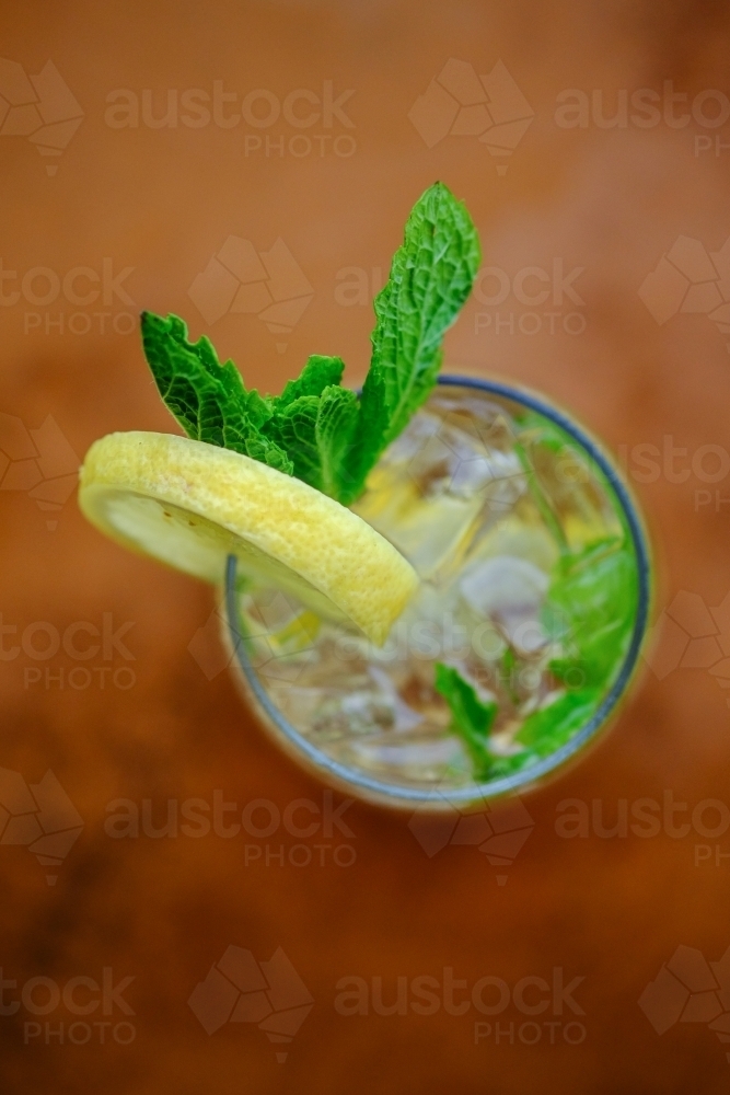 Close up overhead view of a cocktail or mocktail with ice, lemon and mint - Australian Stock Image