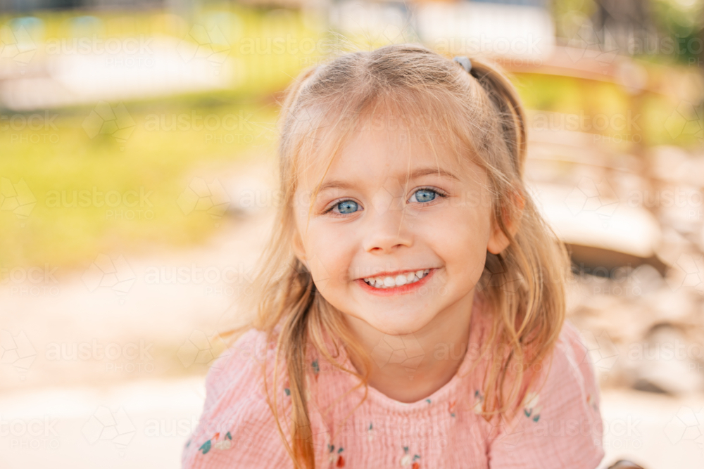 Close up portrait of a preschool age girl with vibrant blue eyes - Australian Stock Image