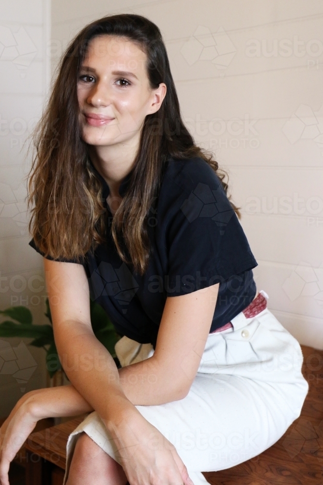 Close up portrait of a young female creative industry worker sitting on her desk - Australian Stock Image