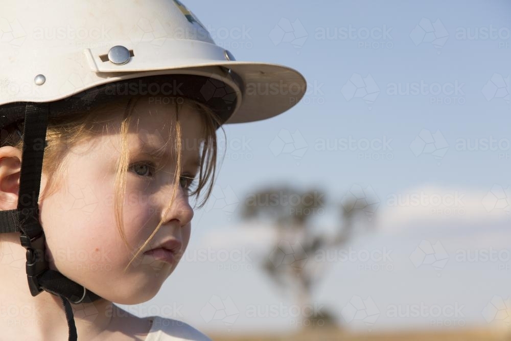Close up portrait of a young girl wearing a horse riding helmet - Australian Stock Image