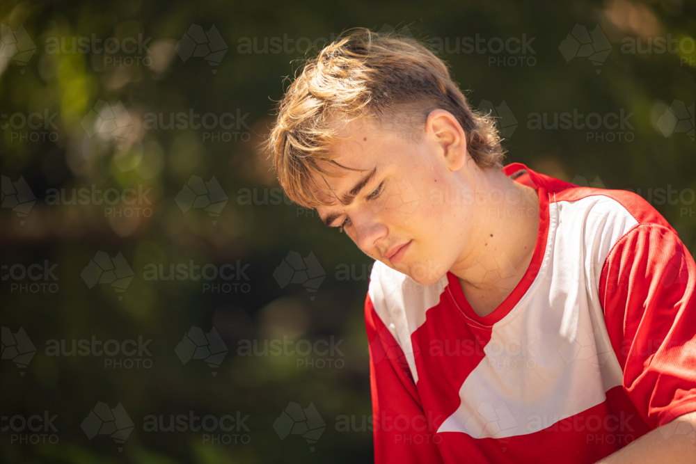 Close up portrait of teenage boy with serious expression - Australian Stock Image