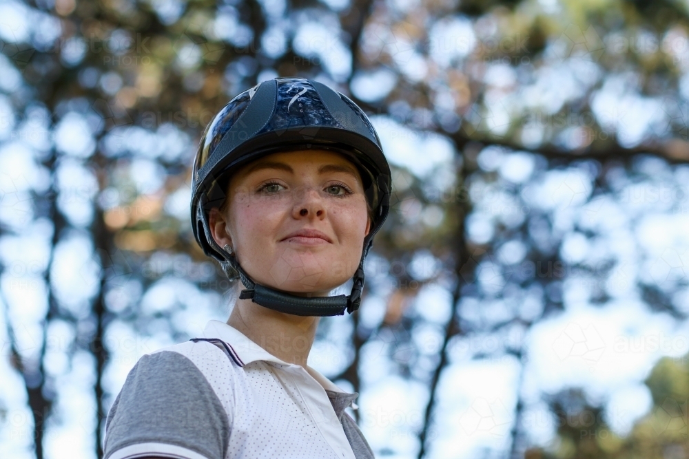 Close up portrait of young female horse rider wearing helmet - Australian Stock Image