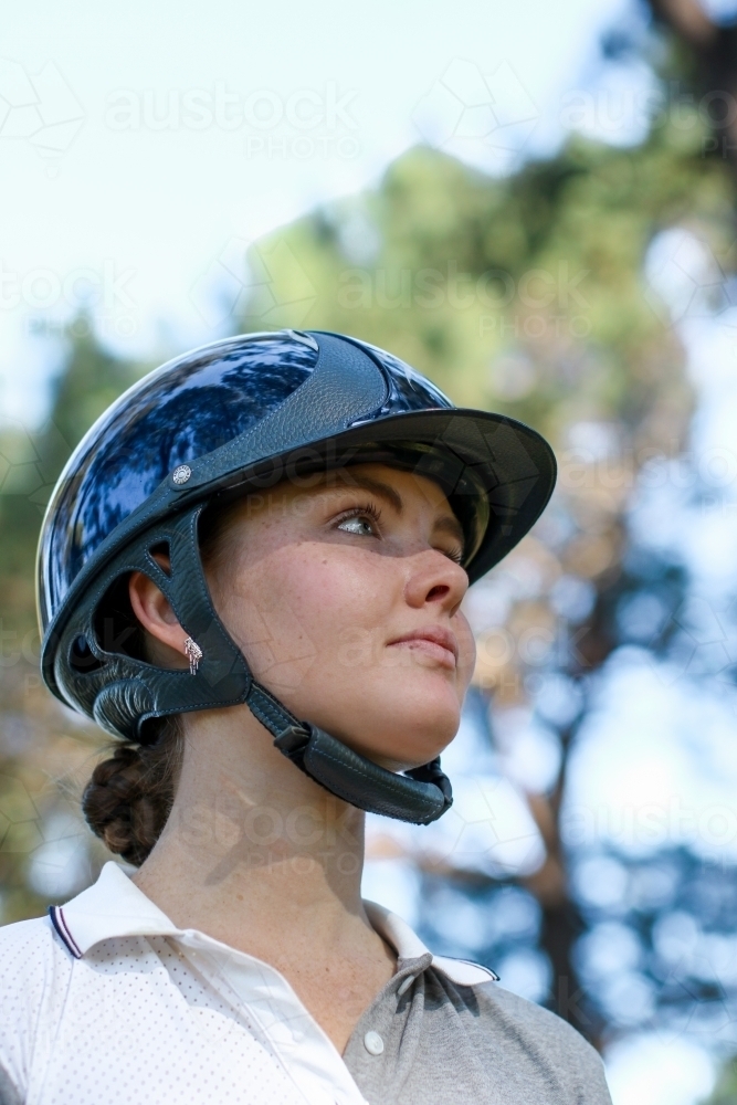 Close up portrait of young female horse rider wearing helmet - Australian Stock Image