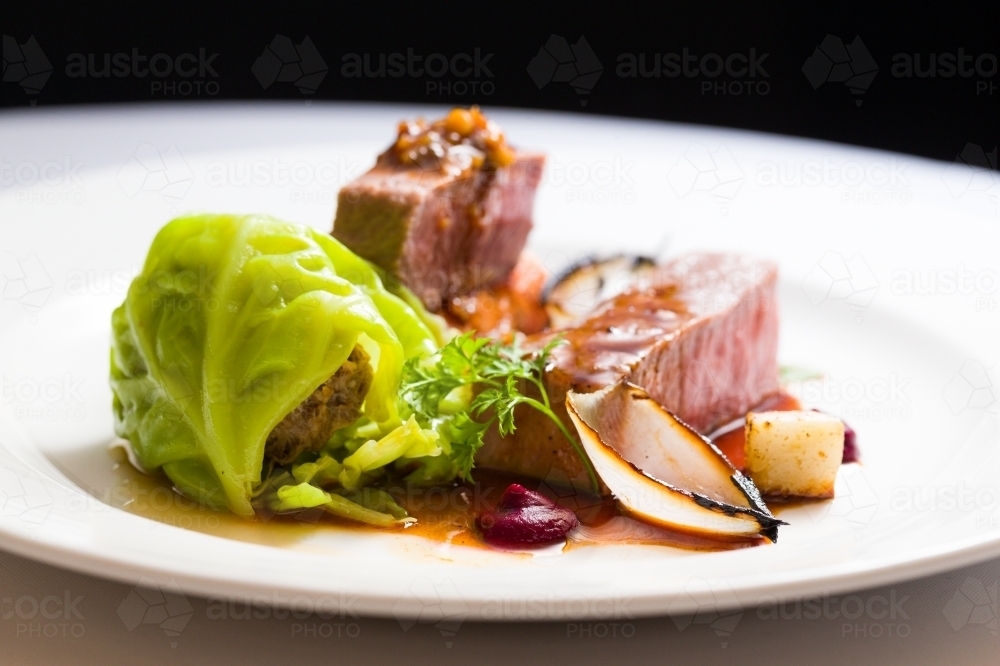Close up shot of a sliced medium rare beef with cabbage and sauce - Australian Stock Image