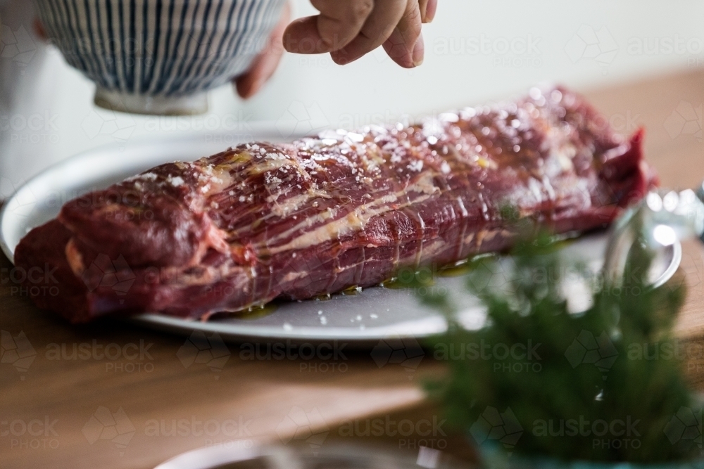 Close up shot of a whole fresh and raw tenderloin beef sprinkled with salt - Australian Stock Image