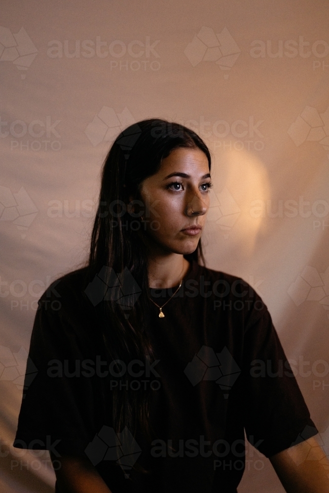 Close up shot of a woman with long hair looking to the right - Australian Stock Image