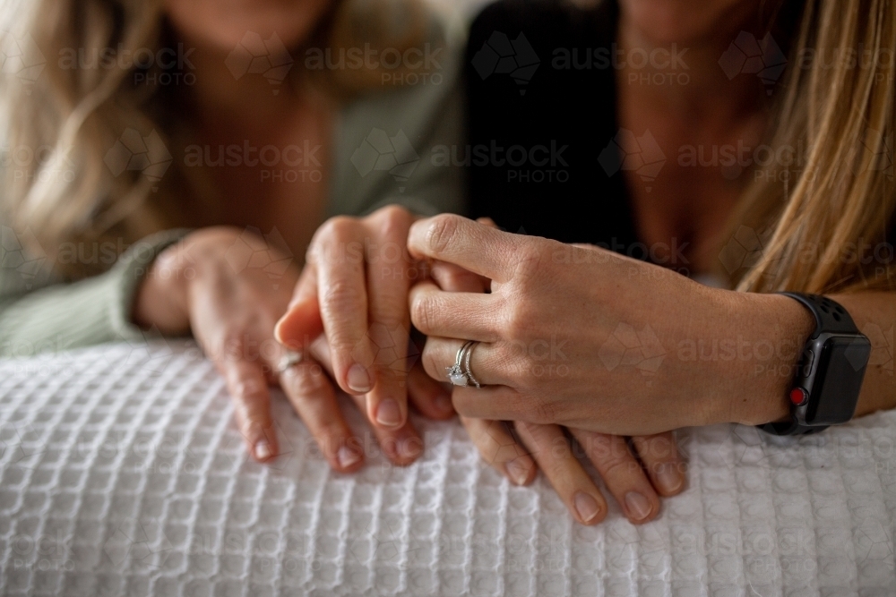 Close up shot of a women's hand holding each other with wedding rings - Australian Stock Image