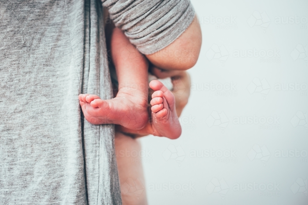 Close up shot of baby's feet and man holding the baby - Australian Stock Image