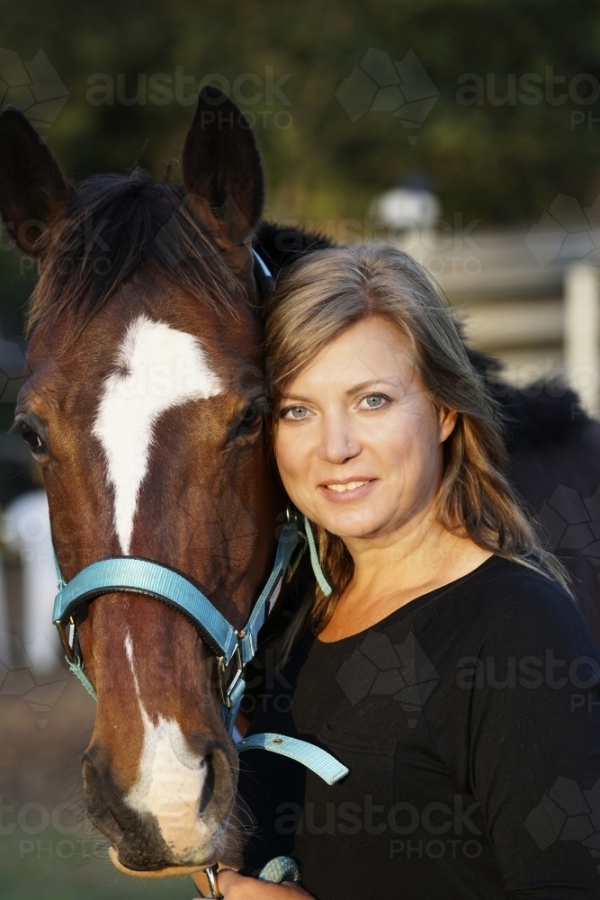 Close up shot of mature woman standing with horse - Australian Stock Image