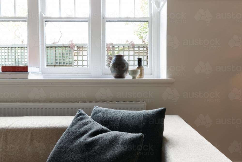 Close up vignette of cushions and window objects in luxury Australian apartment - Australian Stock Image