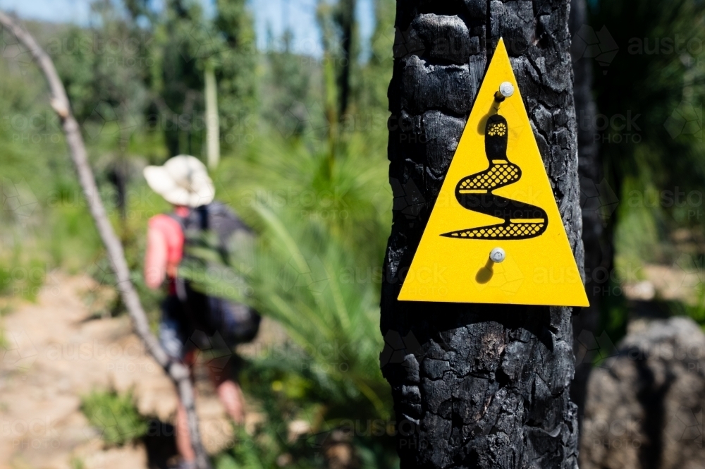 Close up Wagyl trail marker with blurred hiker in background - Australian Stock Image