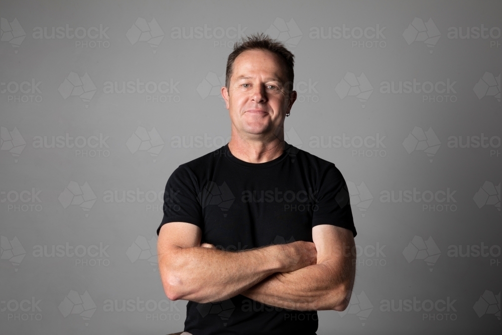 Close -up, waist high, portrait of a man with arms folded. - Australian Stock Image