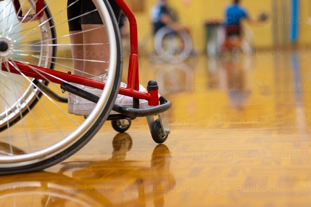 close view of wheels of wheelchair on basketball court - Australian Stock Image