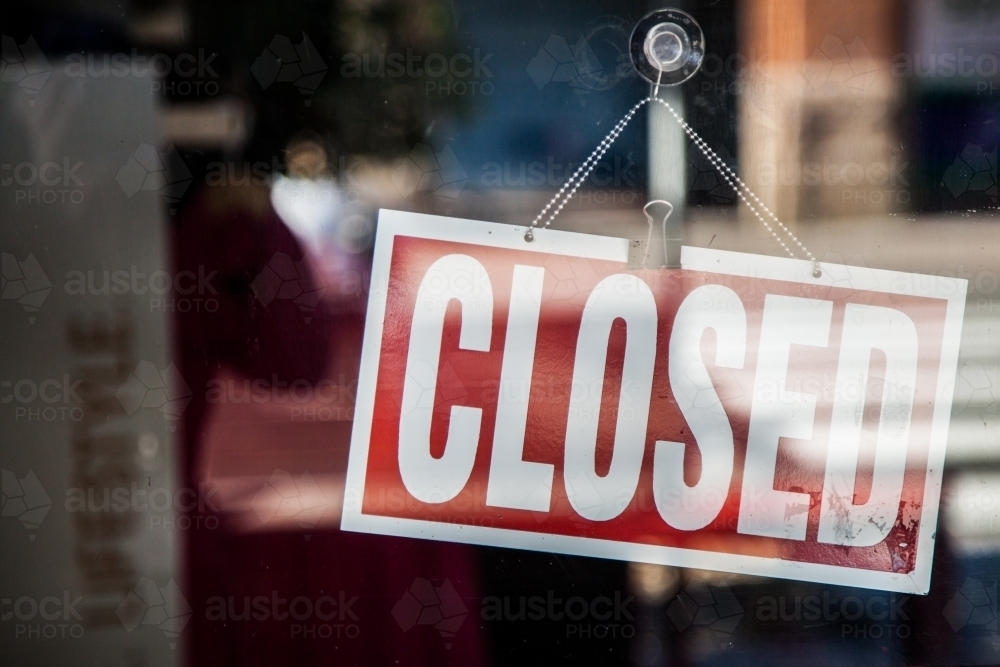 Image of Closed sign hanging in front window of shop Austockphoto