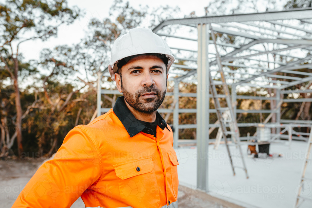 Closeup of a construction worker standing on the construction site. - Australian Stock Image