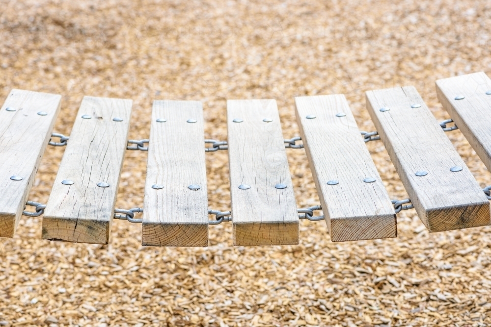 Closeup of a wooden chain bridge in playground sunny day - Australian Stock Image