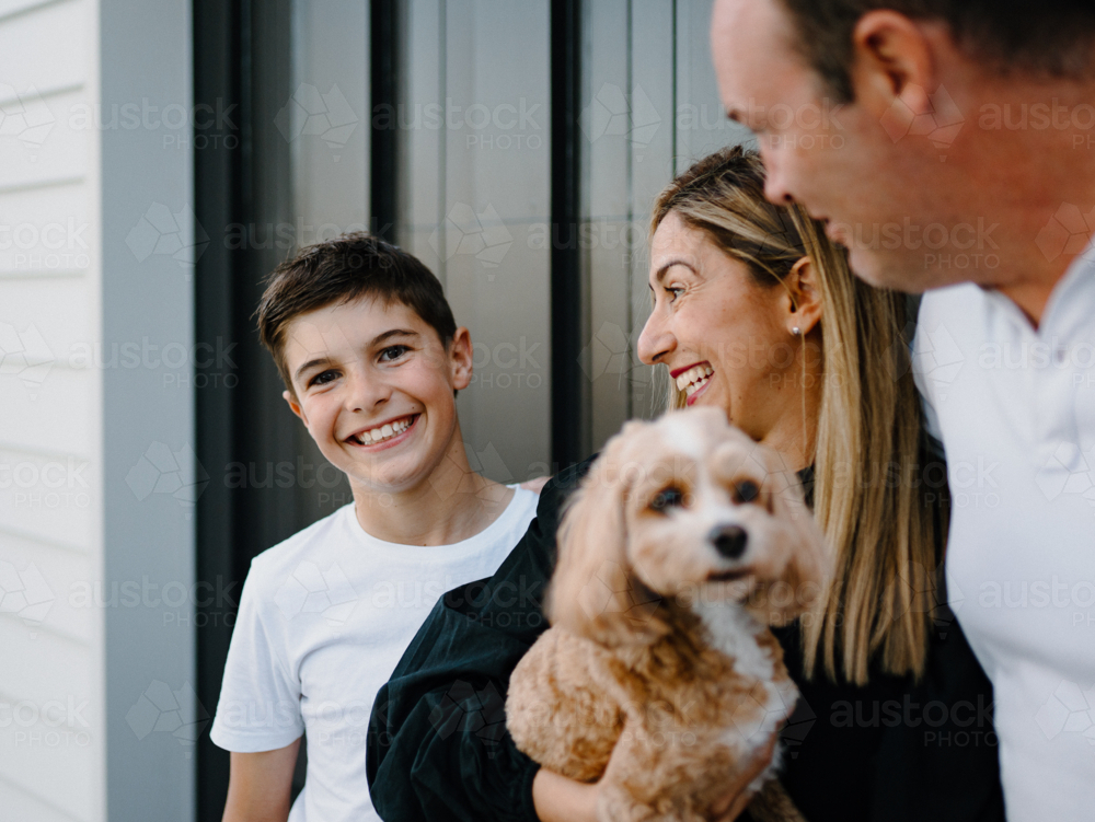 Closeup of a young boy smiling while parents look at him. - Australian Stock Image