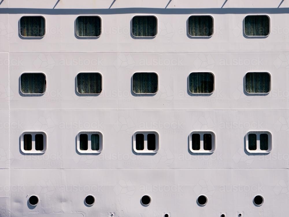 Closeup of rows of windows and portholes in a ship - Australian Stock Image