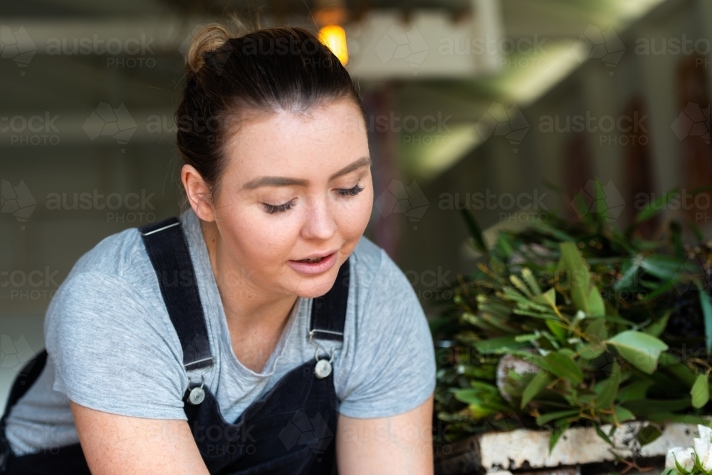 Closeup portrait of an attractive young female florist at work - Australian Stock Image
