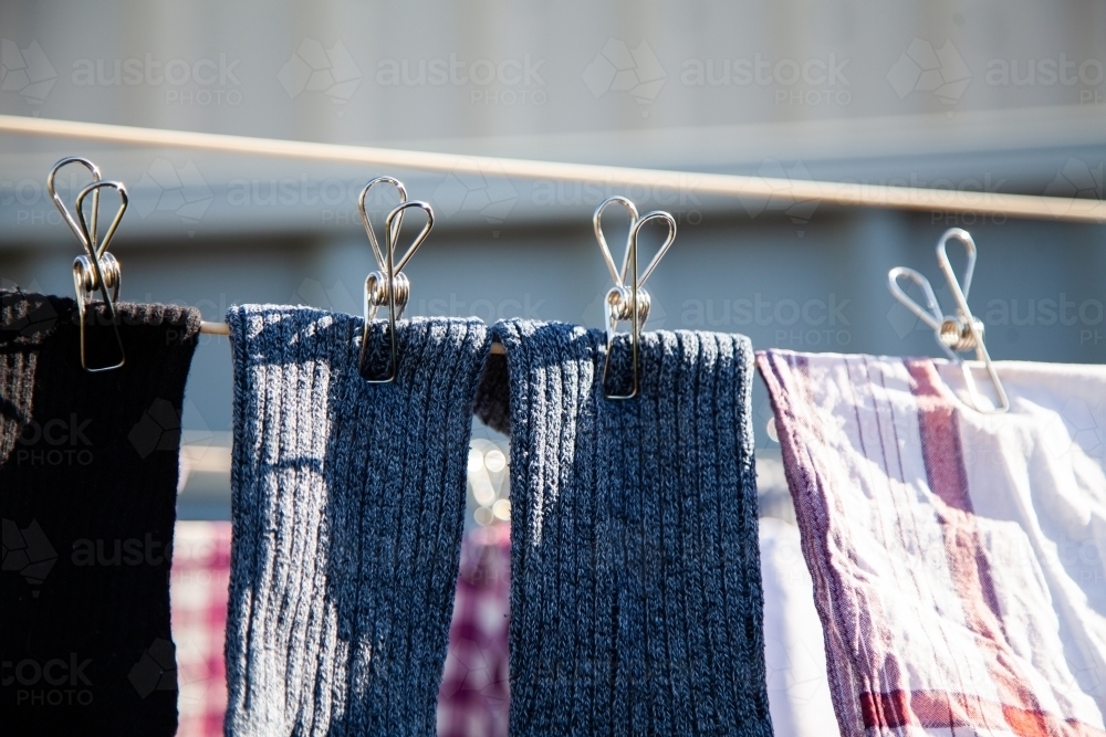 Clothes hanging on a washing line with eco friendly metal pegs - Australian Stock Image