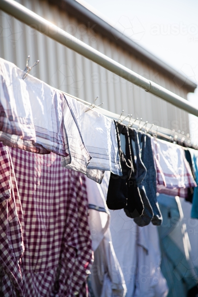Clothes hanging on a washing line with eco friendly metal pegs - Australian Stock Image