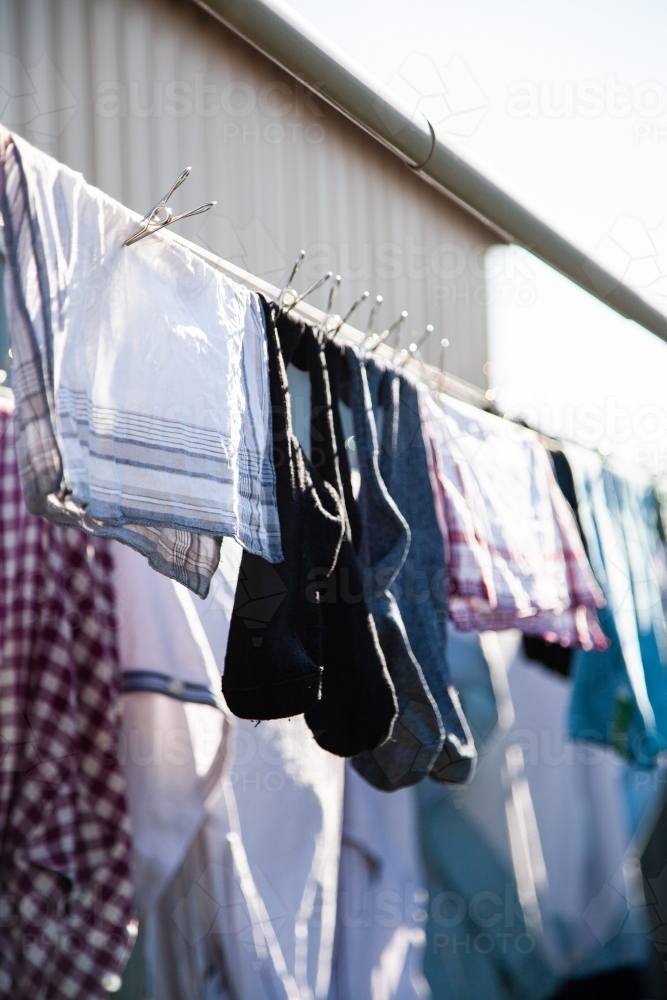 Clothes hanging on a washing line with eco friendly metal pegs - Australian Stock Image