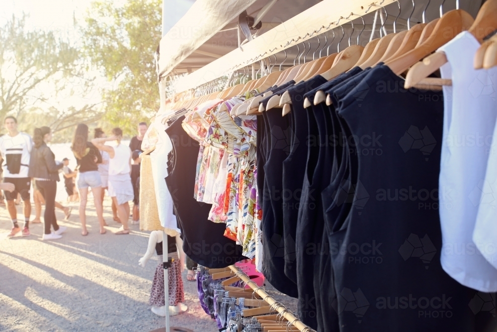 Clothes on rail with teenagers in background - Australian Stock Image