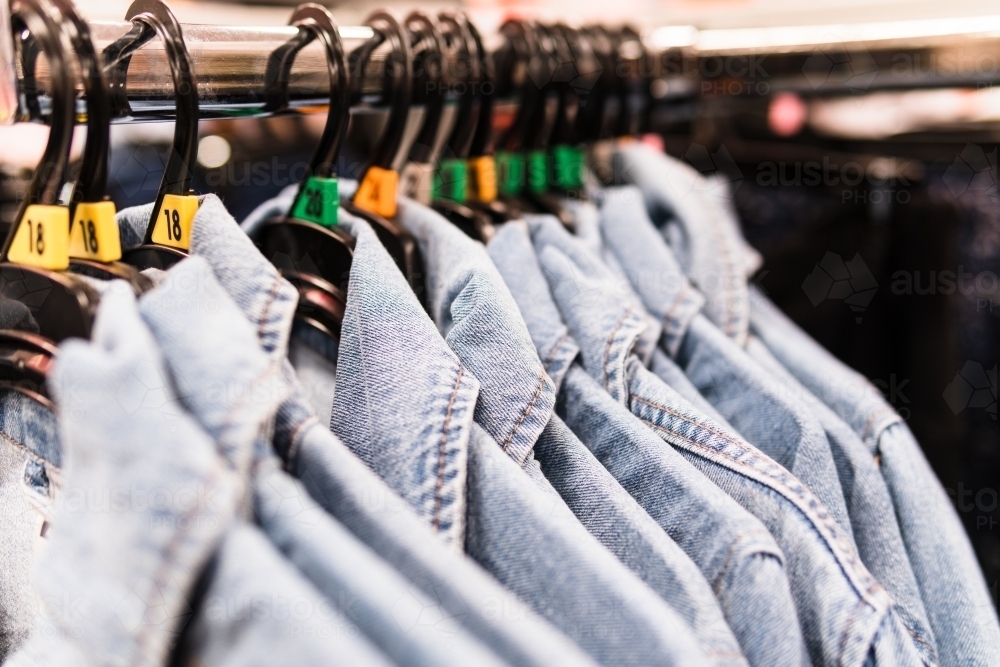 Clothing retails concept. Denim shirts on hangers in clothes store. - Australian Stock Image
