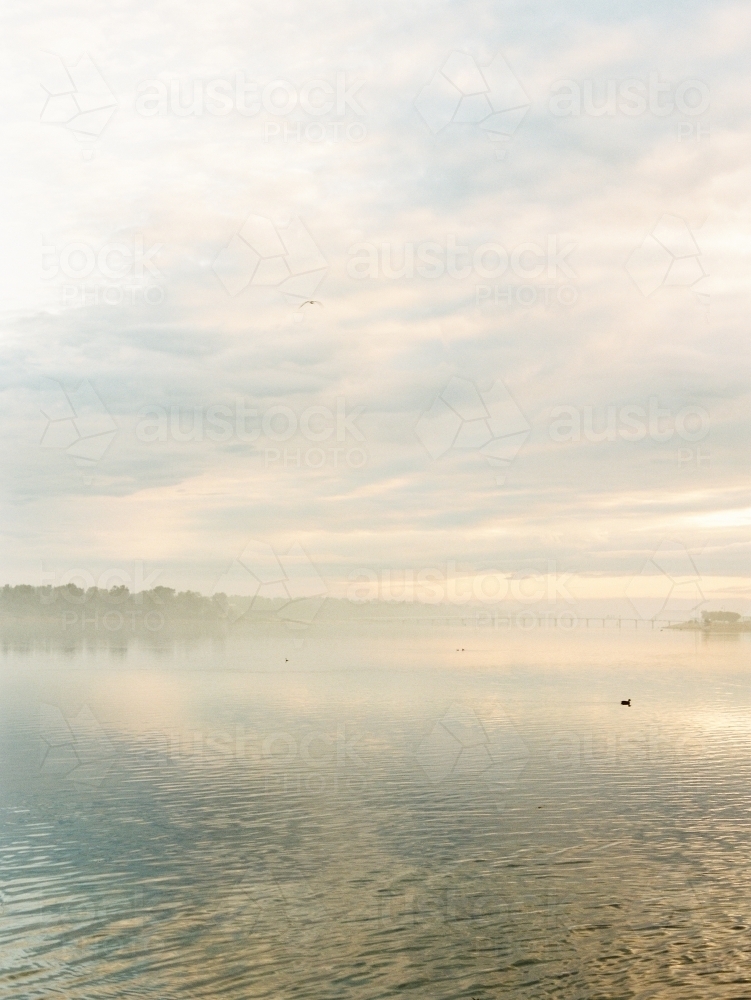 Cloud and mist over water at sunrise. - Australian Stock Image