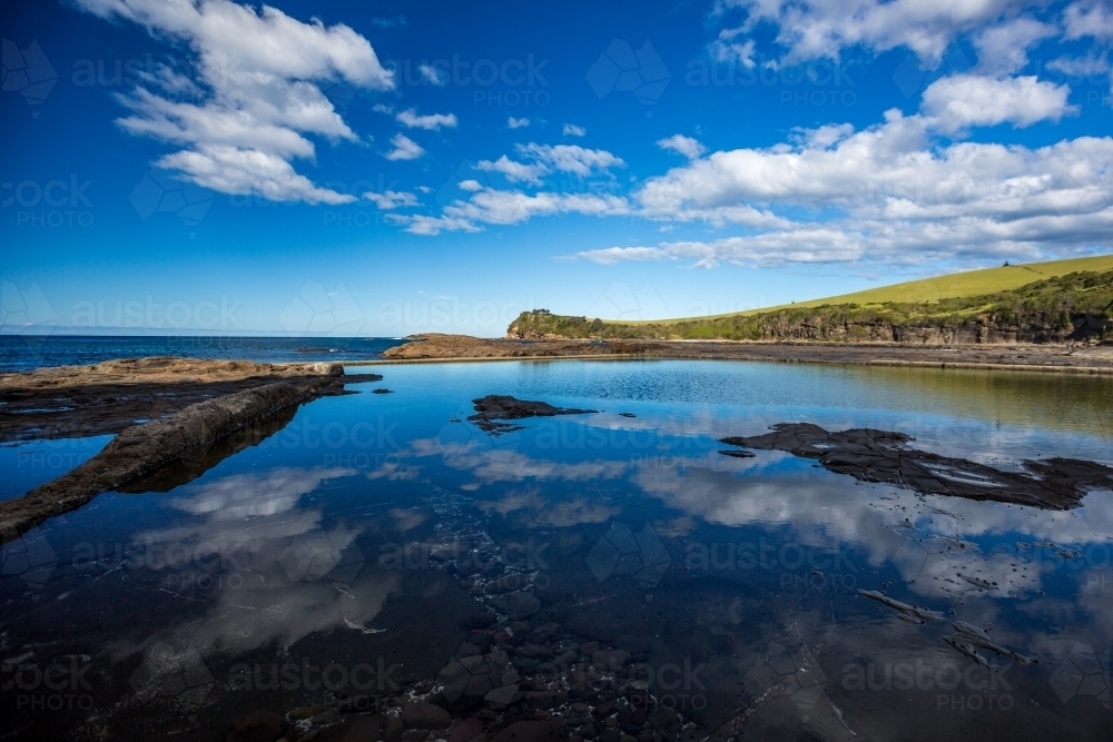 Clouds reflecting in ocean Rockpool on a sunny day - Australian Stock Image