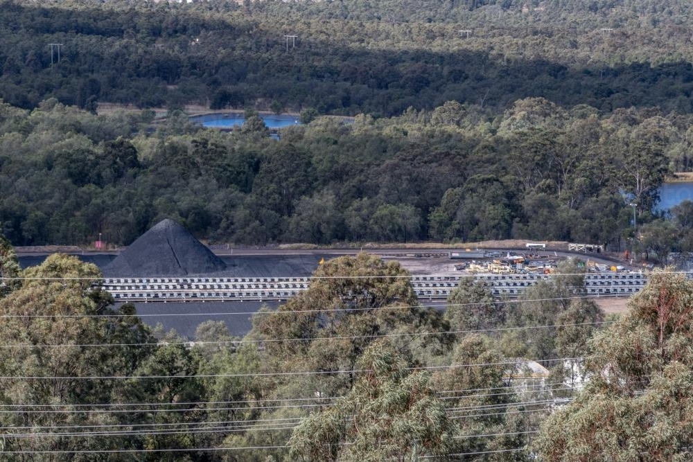 Coal mine tailings and stockpiles forming large mounds across an industrial landscape - Australian Stock Image