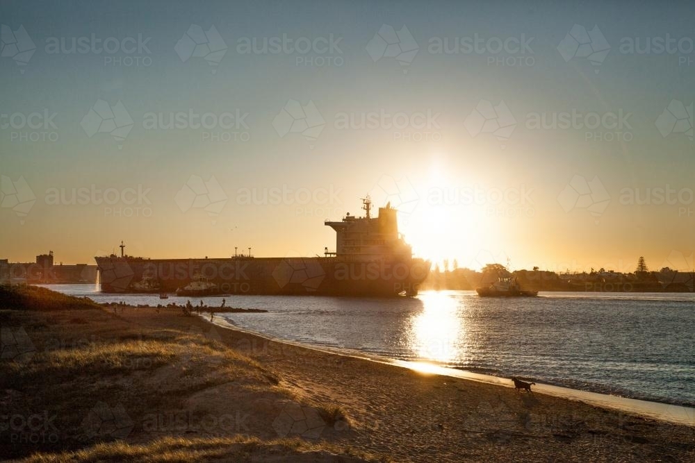 Coal ship coming into Newcastle Harbour at sunset - Australian Stock Image