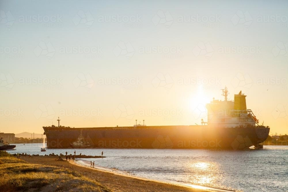 Coal ship coming into Newcastle Harbour at sunset - Australian Stock Image
