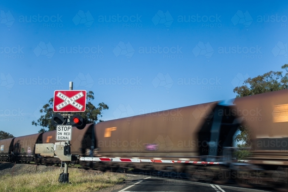 Coal train passing at a level crossing with lights - Australian Stock Image