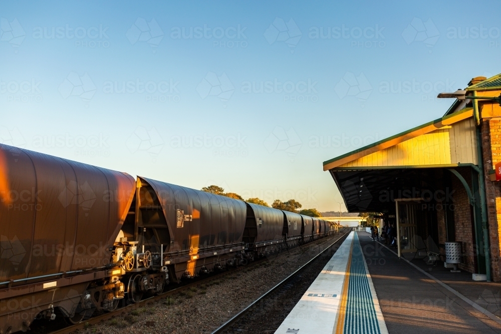 Coal train passing Singleton station at sunrise - Australian Stock Image