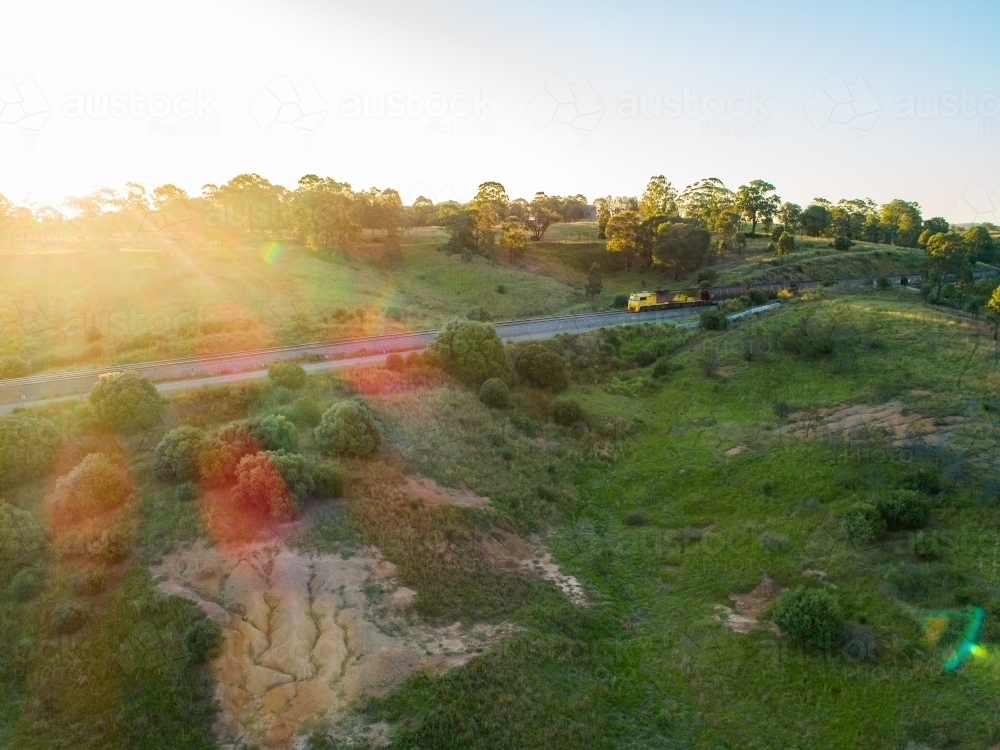 Coal train seen from drone on railway track through green landscape in Hunter Valley - Australian Stock Image